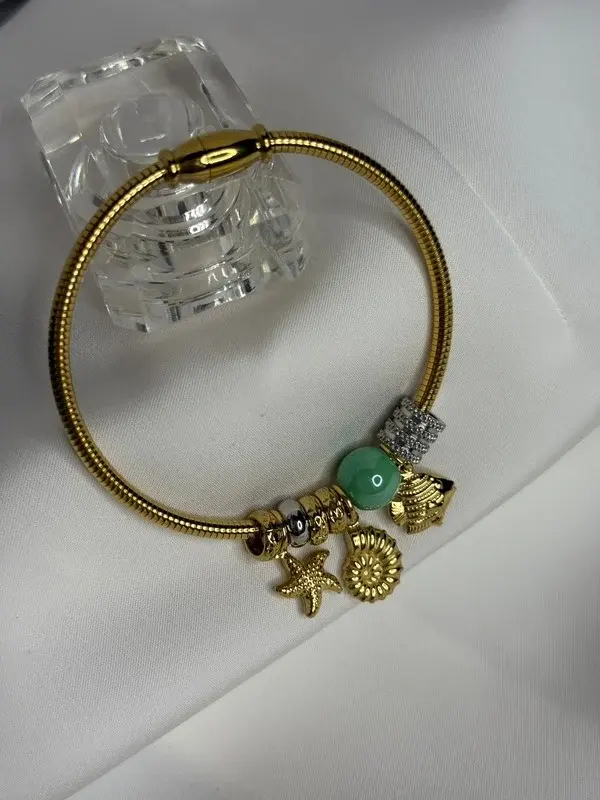 Charms Jade — Charms dorados con cuenta verde.